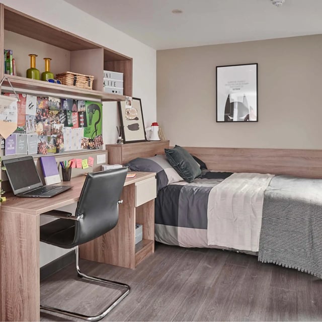 Desk bed pillows framed art and shelves bedroom at Trinity View Coventry in Coventry Student Accommodation