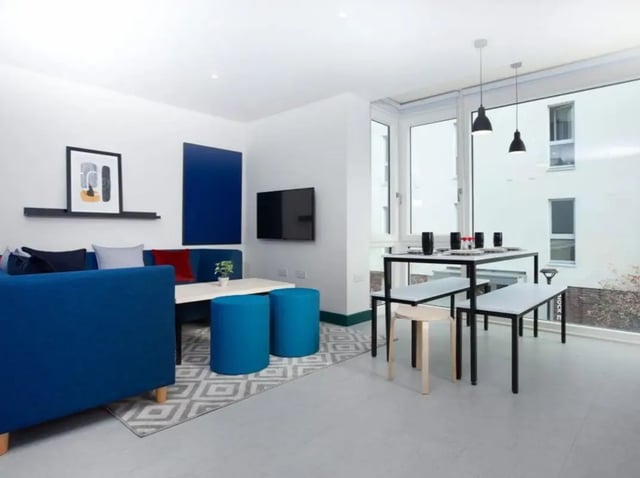 Blue couch dining table and stools living room at Highlight Parkgate in Dublin Student Accommodation