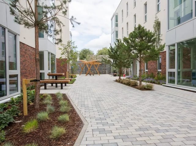 Wooden benches and tables in courtyard exterior at Highlight Parkgate in Dublin Student Accommodation