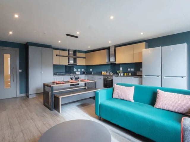 Teal sofa dining table kitchen and fridge living room at Highlight Thomas Street in Dublin Student Accommodation