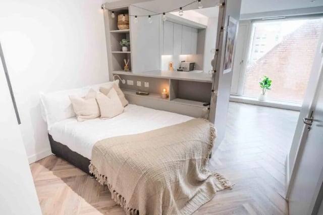 Bed with shelves and kitchen beyond bedroom at Cork Street Residence in Dublin Student Accommodation