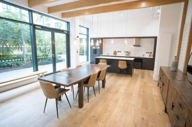 Wooden dining table with chairs and kitchen Image Type communal kitchen at Cork Street Residence in Dublin Student Accommodation