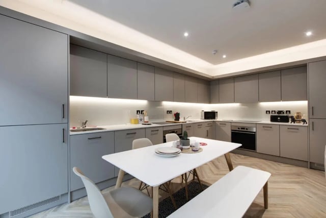 Modern grey cabinets white table bench kitchen area at Cork Street Residence in Dublin Student Accommodation