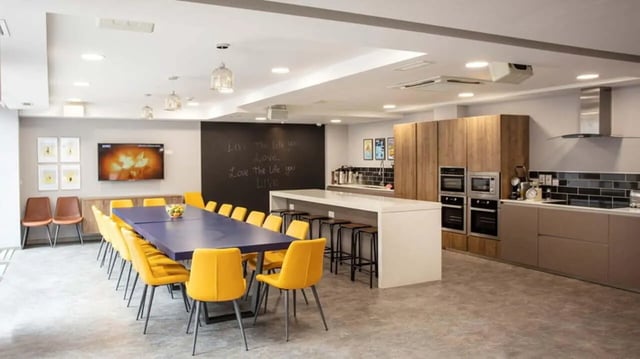 Long table yellow chairs kitchen island communal area at Liv Dublin in Dublin Student Accommodation