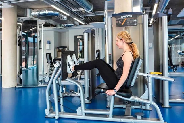Woman exercising on leg press machine gym area at Highfield House in Dublin Student Accommodation
