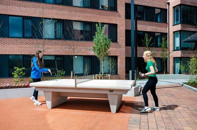 Two women play ping pong outdoors playing area at Highfield House in Dublin Student Accommodation