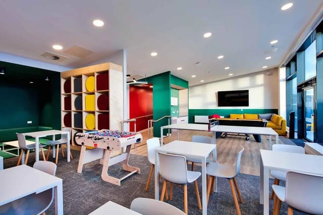 Foosball table tables chairs yellow sofa living room at Highfield House in Dublin Student Accommodation