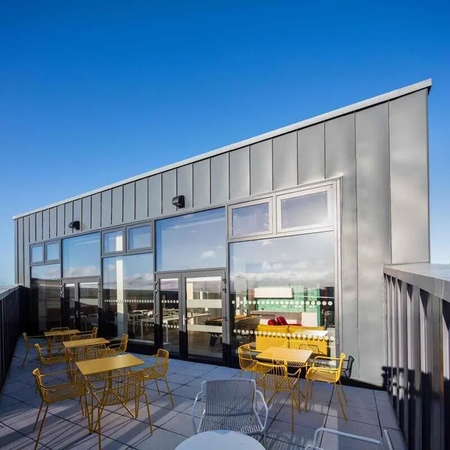Yellow tables and chairs on rooftop terrace exterior at Highfield House in Dublin Student Accommodation