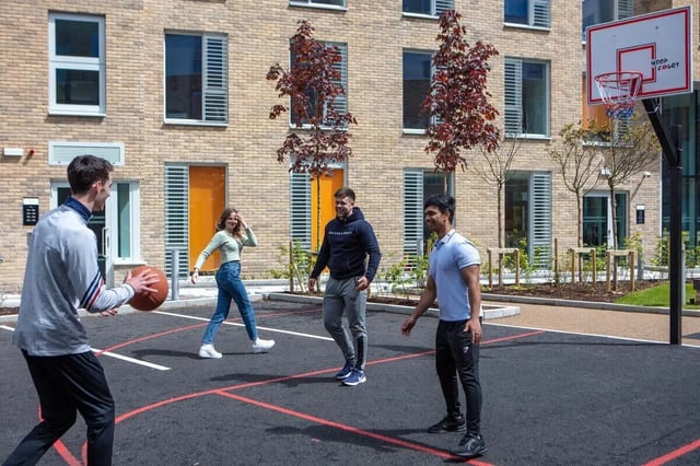 Students playing basketball on an outdoor court exterior at The Westwood in Galway Student Accommodation