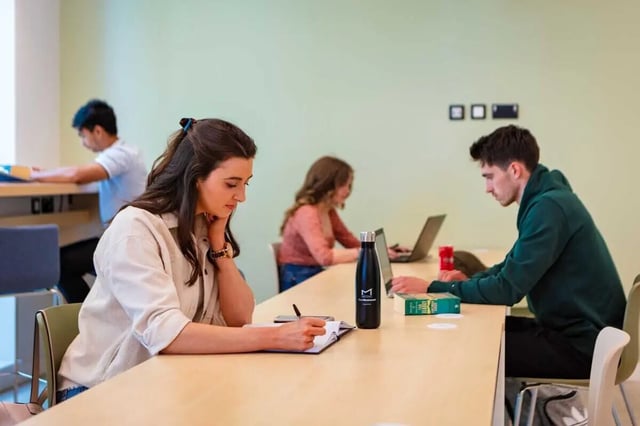 Students studying at desks with laptops and books study area at The Westwood in Galway Student Accommodation