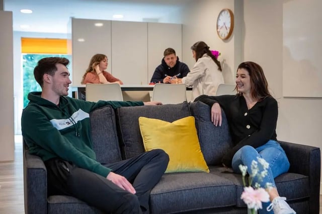 Couch with people sitting and table living room at The Westwood in Galway Student Accommodation