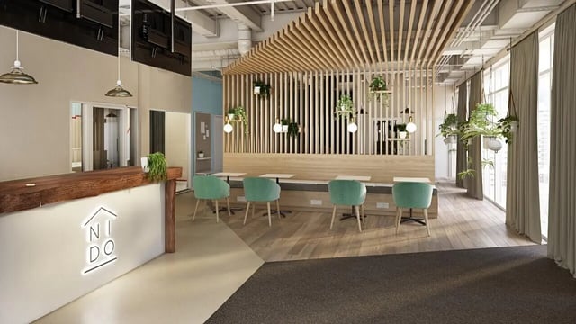 Reception desk with Nido logo and communal area. at Curraheen Point in Cork Student Accommodation