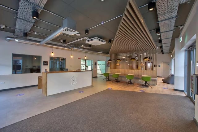 Reception desk with green stools common area at Curraheen Point in Cork Student Accommodation