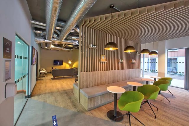 Green chairs tables bench lounge area study room living area at Curraheen Point in Cork Student Accommodation