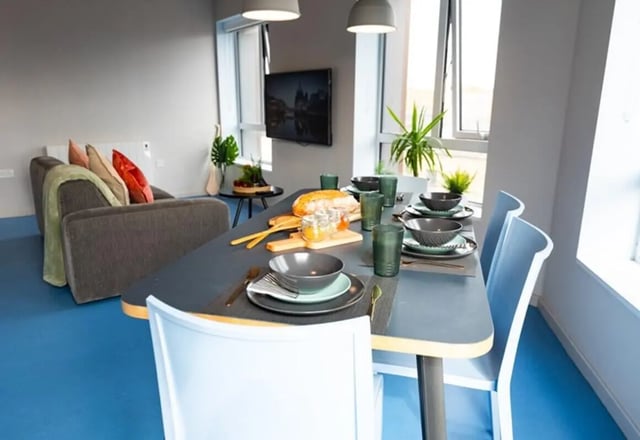 Dining table with place settings and sofa living room at Stephen's Quarter in Dublin Student Accommodation