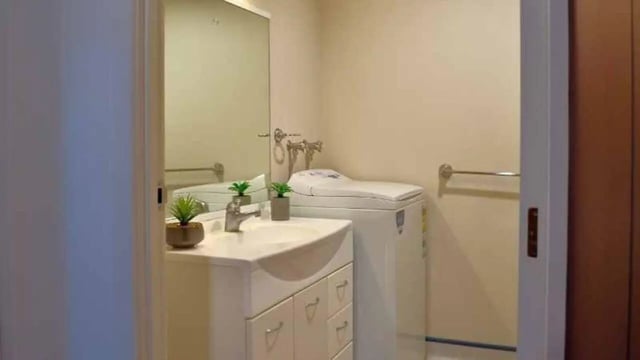 Sink toilet washing machine towel rail bathroom at UniLodge Stafford House in Wellington Student Accommodation