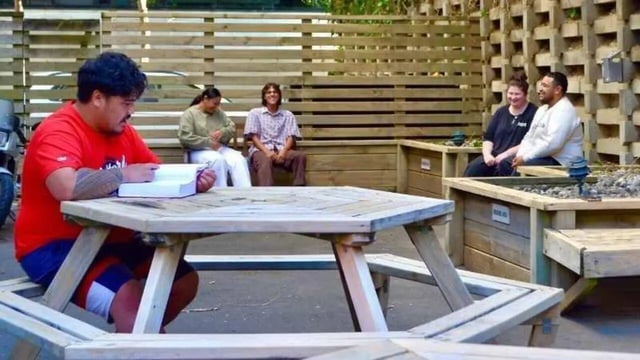 People sit around hexagonal table exterior at UniLodge Stafford House in Wellington Student Accommodation
