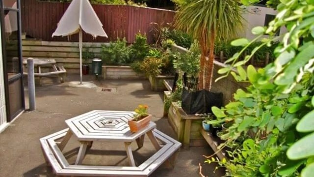 Octagonal table umbrella plants and seating exterior at UniLodge Stafford House in Wellington Student Accommodation