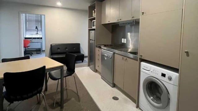Dining table sofa kitchen appliances washing machine living area at UniLodge Stafford House in Wellington Student Accommodation