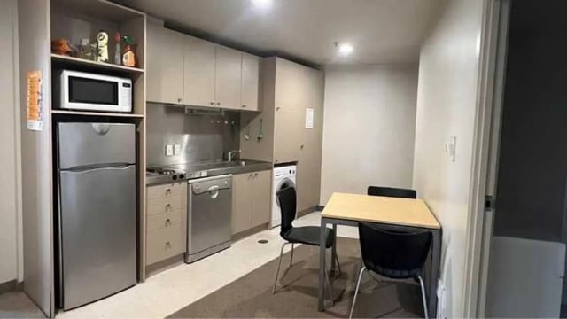Fridge microwave cabinets dishwasher dining table chairs kitchen at UniLodge Stafford House in Wellington Student Accommodation