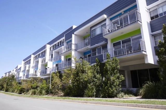 Modern apartment building with balconies and trees exterior at Griffith University Village Gold Coast in Gold Coast Student Accommodation