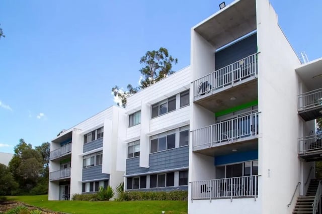 Modern apartment building with balconies and windows exterior at Griffith University Village Gold Coast in Gold Coast Student Accommodation