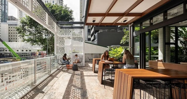 Students working at tables on outdoor patio area at Iglu Brisbane City in Brisbane Student Accommodation