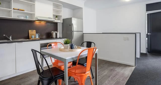 Kitchen table with chairs and kitchen counter area at Iglu Kelvin Grove in Brisbane Student Accommodation