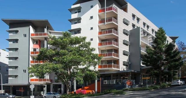 Modern apartment building with balconies and trees exterior at Iglu Kelvin Grove in Brisbane Student Accommodation