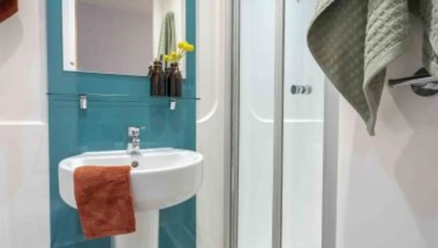 Sink with orange towel shower stall bathroom at iQ Abacus House in Brighton Student Accommodation
