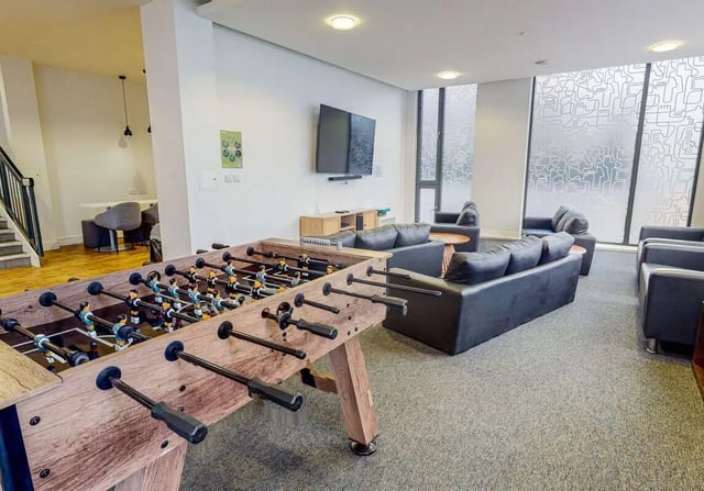 Foosball table leather sofas television living area at iQ Abacus House in Brighton Student Accommodation