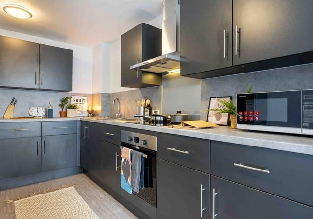 Dark grey cabinets microwave sink oven kitchen at iQ Abacus House in Brighton Student Accommodation