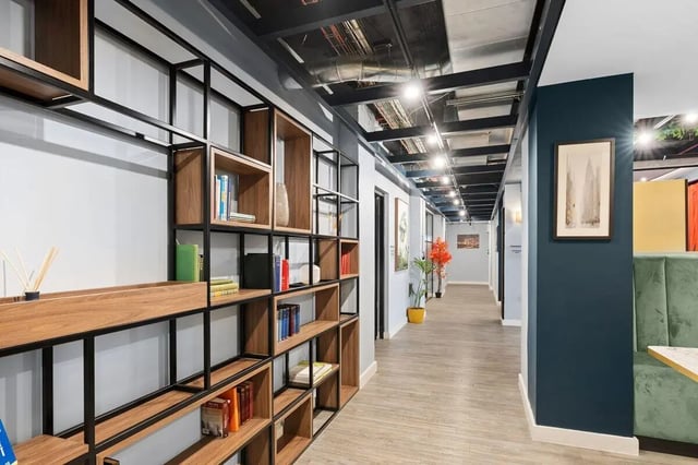 Books on wall shelves and a hallway interior. at Pennine House in Leeds Student Accommodation