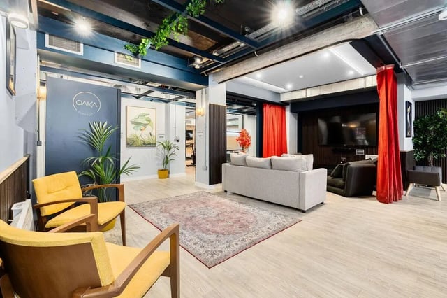 Two yellow armchairs grey sofa and rug communal living room at Pennine House in Leeds Student Accommodation