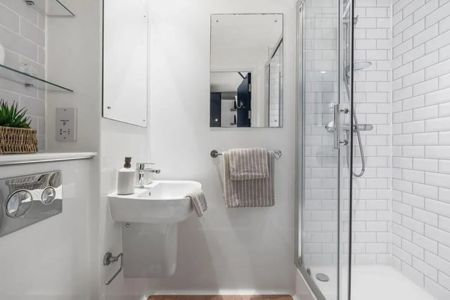 Sink shower mirror and towel rack bathroom at Pennine House in Leeds Student Accommodation