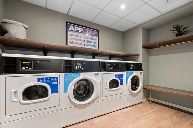 Multiple washing machines and dryers laundry area at Pennine House in Leeds Student Accommodation