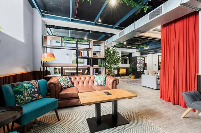 Chesterfield sofa table lamp plant bookshelf lounge living room at Pennine House in Leeds Student Accommodation