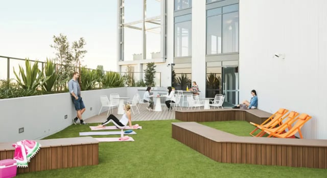 People relaxing on rooftop with seating and lounge chairs at Scape South Bank in Brisbane Student Accommodation