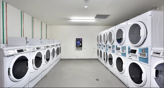Multiple washing machines and dryers stacked laundry room at Scape Glebe in Sydney Student Accommodation