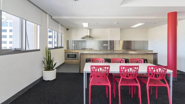 White table with pink chairs kitchen area at UniLodge @ Metro Adelaide in Adelaide Student Accommodation