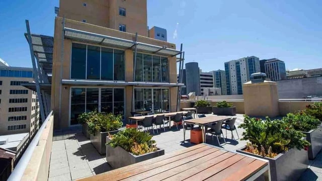 Rooftop tables chairs planters with greenery exterior at UniLodge @ Metro Adelaide in Adelaide Student Accommodation