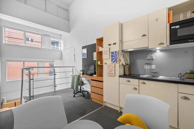 Studio apartment kitchen desk with chair and windows. at Algernon Firth in Leeds Student Accommodation