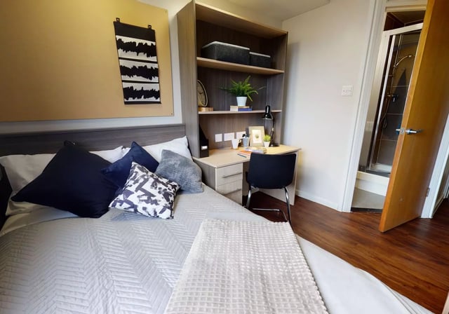 Bed desk bookshelf and shower cubicle bedroom at iQ Lambert & Fairfield House in Manchester Student Accommodation