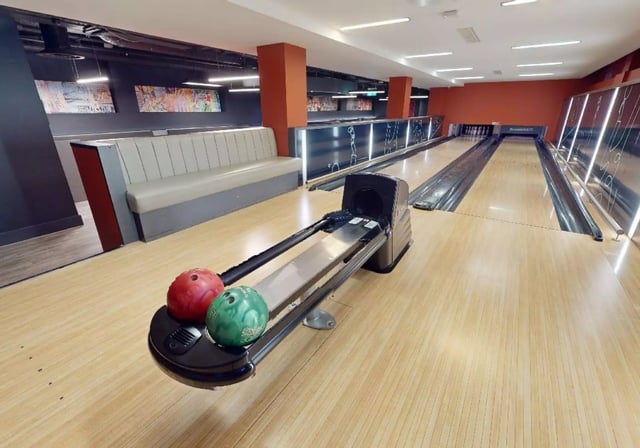 Bowling lanes with balls and seating playing area at iQ Lambert & Fairfield House in Manchester Student Accommodation