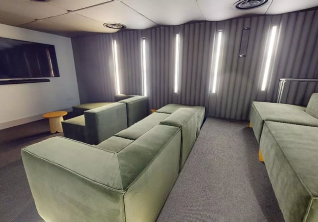 Modern lounge with green sectional sofas and TV living room at iQ Lambert & Fairfield House in Manchester Student Accommodation