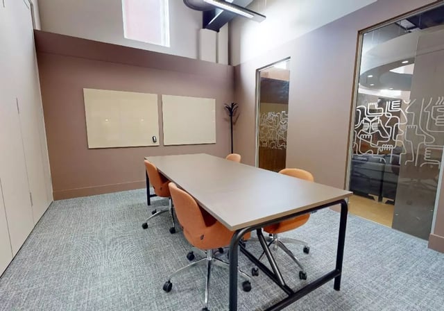 Table with orange chairs and whiteboards meeting room at iQ Lambert & Fairfield House in Manchester Student Accommodation