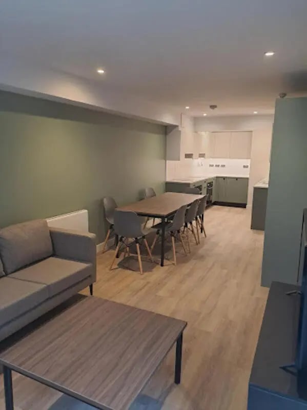 Sofa dining table chairs kitchen cabinets open plan living room at Arasain P&V in Dublin Student Accommodation