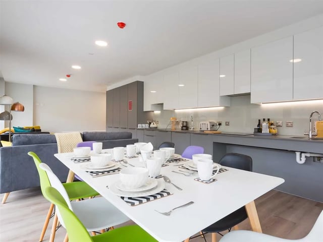Dining table with plates and chairs kitchen area at Brickworks in Dublin Student Accommodation