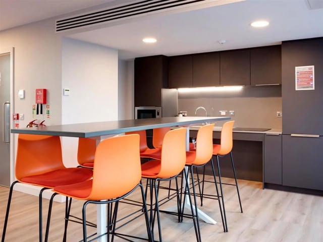 Orange chairs at breakfast bar modern kitchen kitchen at Brickworks in Dublin Student Accommodation