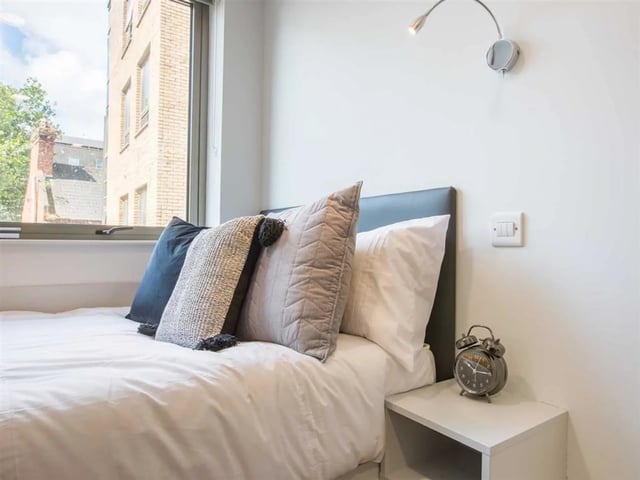 Bed with pillows alarm clock beside bedside table bedroom at Brickworks in Dublin Student Accommodation